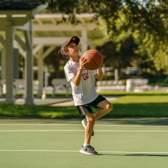 Youth in hat and shorts preparing to shoot a basketball